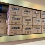 انبار پخش عمده باتری موبایل شامل جعبه های کارتن شده پر از باتری های آیفون و سامسونگ و شیائمی