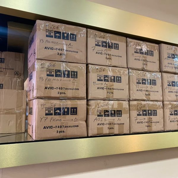 انبار پخش عمده باتری موبایل شامل جعبه های کارتن شده پر از باتری های آیفون و سامسونگ و شیائمی